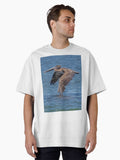 Flying Brown Pelican Touches Water with Wing Oversized T-Shirt | Graphic T-Shirt for Unisex