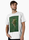 A resilient green plant sprouts from a crack in a wall of broken green patterned tiles showcasing na T Shirt